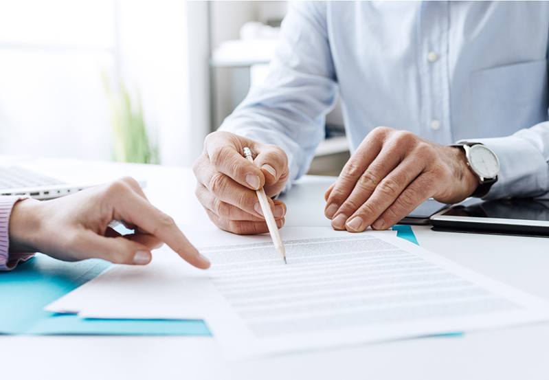 Photo of insurance agent with a client filling out paperwork